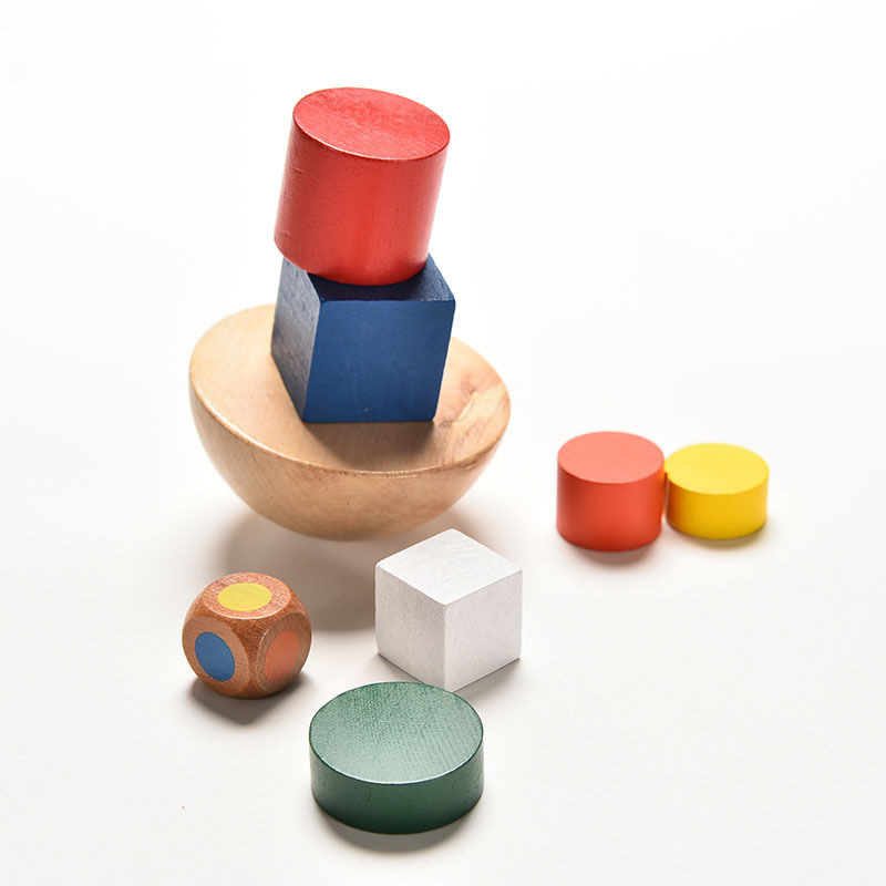 Jeu d’équilibre en bois entre cubes et cylindres de couleur et un dés pour définir quel objet mettre au dessus
