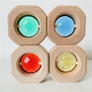 Kaléidoscope en forme de cubes en bois, au nombre de 4 de couleur bleu, vert rouge et jaune.