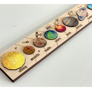 Un puzzle système solaire en bois posé sur un fond blanc.