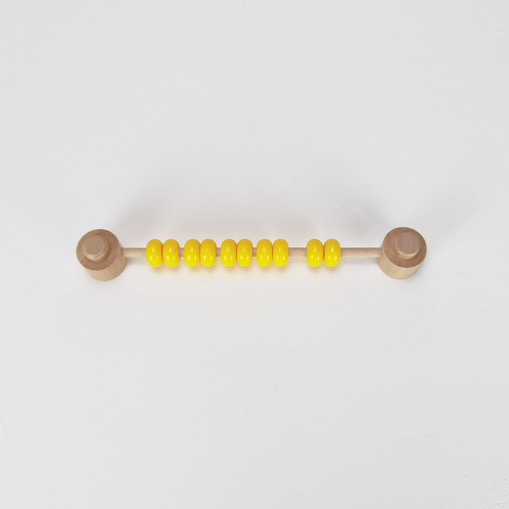 Jeu de perles colorées en jaune sur une tige en bois