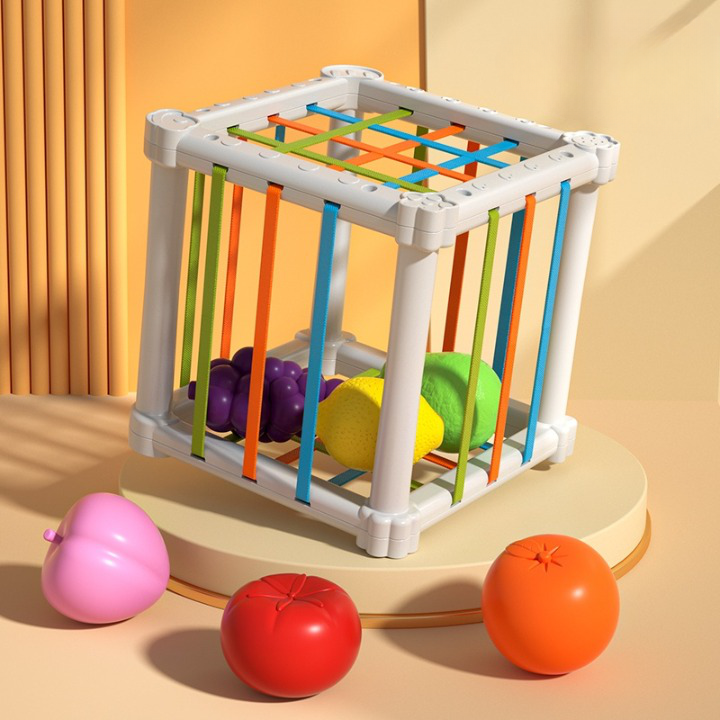 Jouet pour bébé, montessori, boîte à fruits, cube avec des bandes souples coloré qui peuvent être tendu pour laisser passer les fruits à l'intérieur