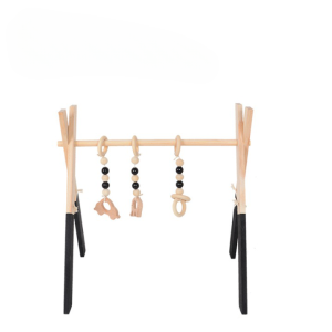 Portique en bois avec 3 jouets suspendus pour bébé, de couleur noir au niveau des pieds, avec un tapis blanc en dessous