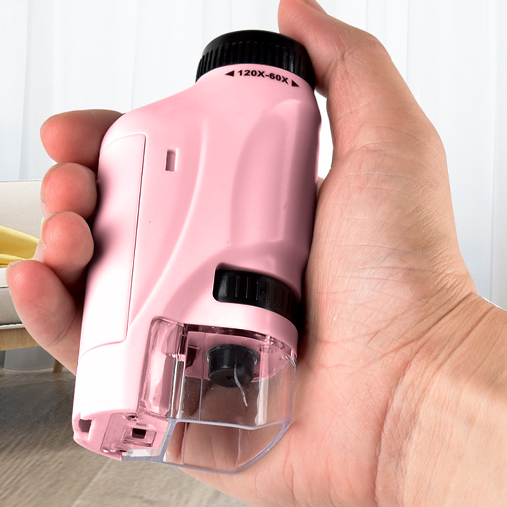 Mini microscope de poche pour enfant, de couleur rose dans une main