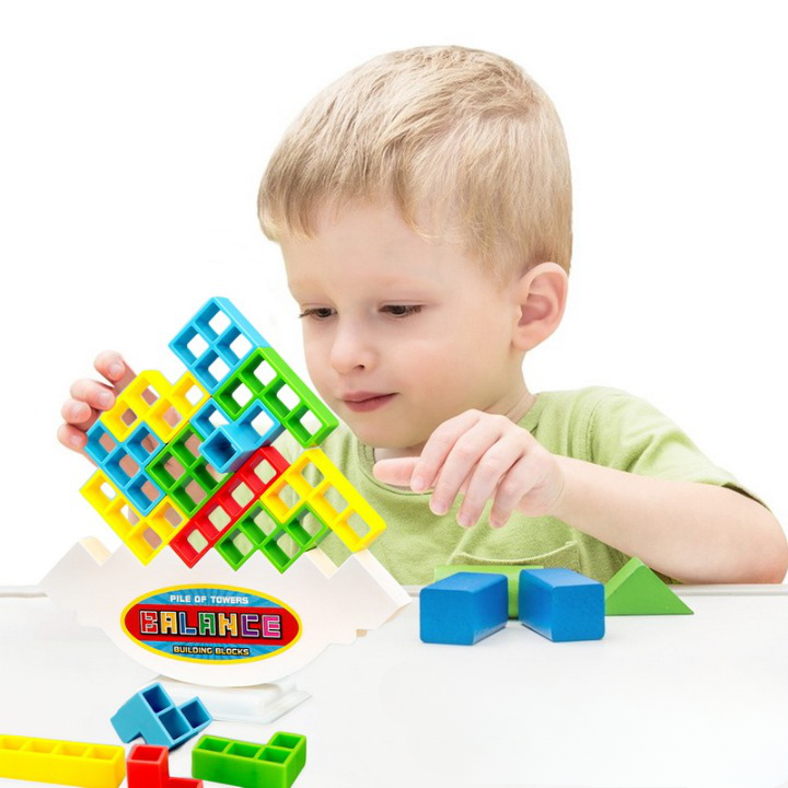 Jeu tetris d'empilage et d'équilibre pour enfant, avec un enfant en train de jouer derrière la pyramide qu'il est en train de former